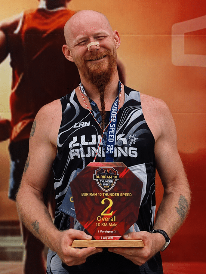 Mister Finn online running coach with a Buriram running trophy in Thailand